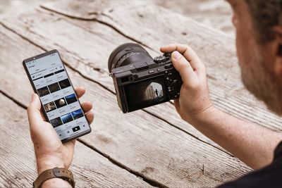 Usage image showing a user transferring images from the camera to a smartphone