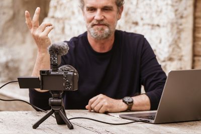 Usage image showing a user live streaming with the camera standing on the extension grip stand