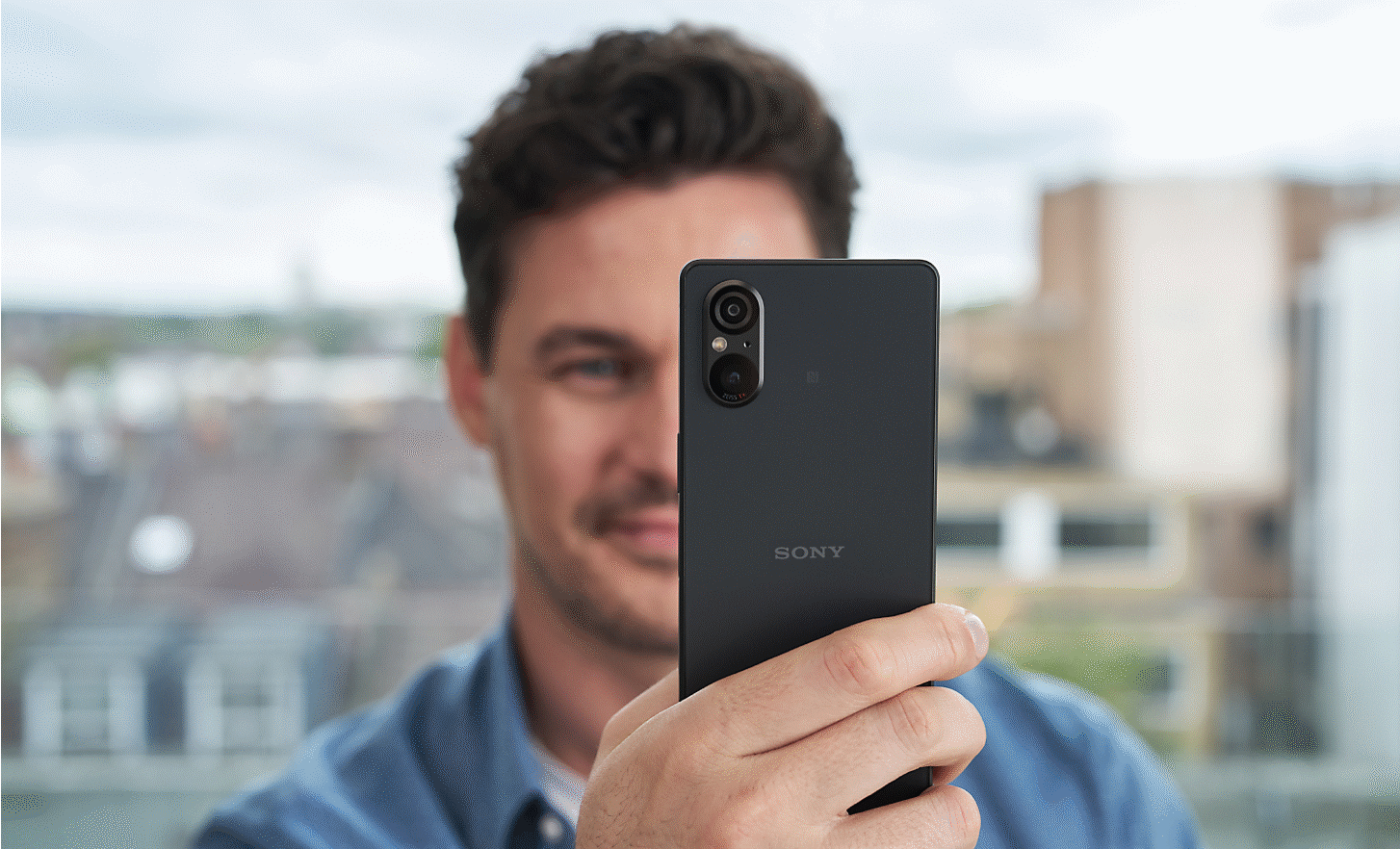 Close up image of a person taking a photo with an Xperia 5 V