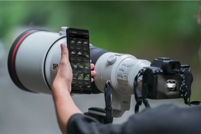 Immagine che mostra l'uso di uno smartphone accanto alla fotocamera durante lo scatto