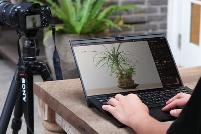 Hình ảnh một người sử dụng PC phía sau máy ảnh gắn chân máy
