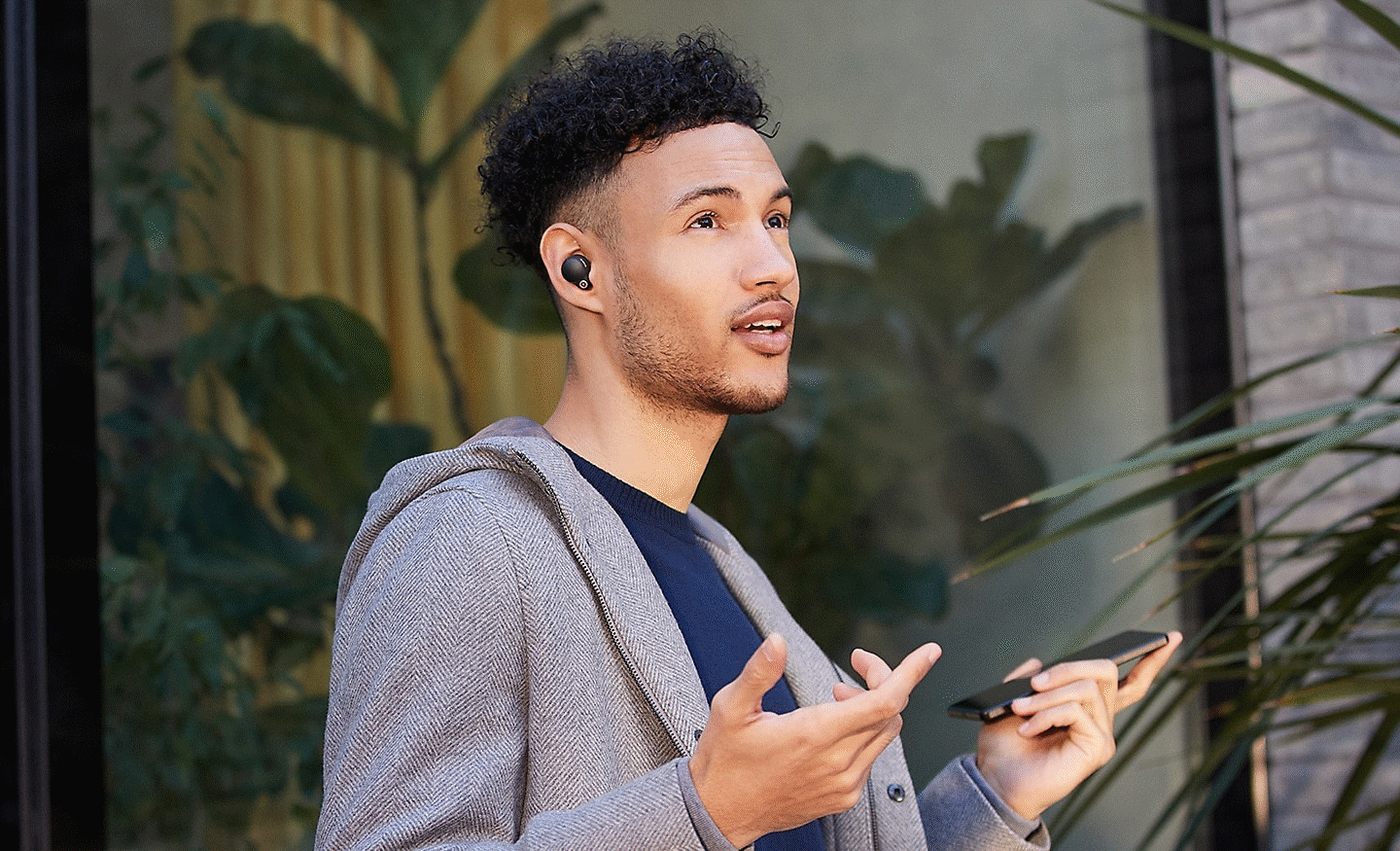 Mand med WF-1000XM4-hovedtelefoner på, og som taler håndfrit på sin smartphone