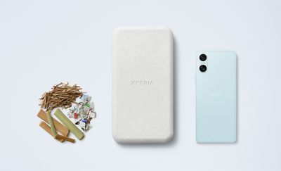 An Xperia 10 VI handset in blue, alongside the recycled packaging and a pile of reusable materials.