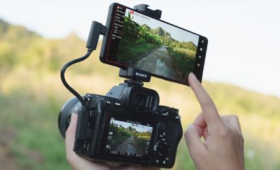 The Xperia 1 VI mounted on top of a traditional SLR camera, with bot showing the same display.