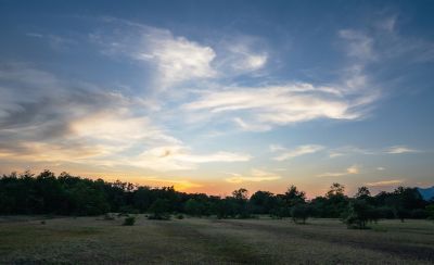 Immagine paesaggistica del sole che tramonta su una collina.