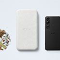Una selección de materias primas reutilizables junto con el embalaje de Sony y la carcasa exterior de un smartphone.