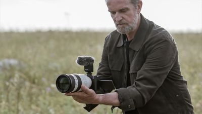 Imagen de un usuario grabando un video sin trípode con un lente teleobjetivo montado