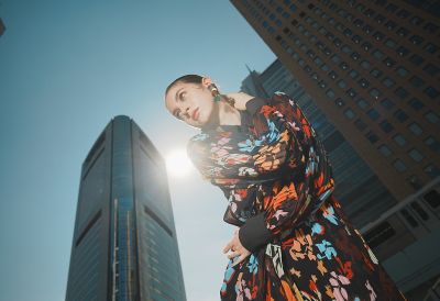 Image of a woman posing with a building in the background