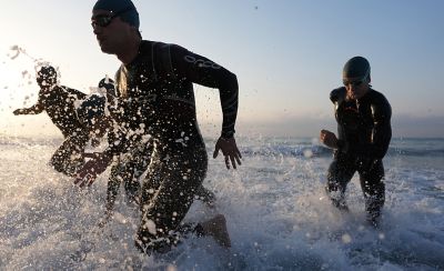 Imagen de ejemplo de cuatro triatletas saliendo del agua