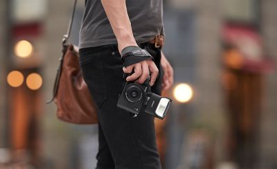 Hình ảnh sử dụng cho thấy một người đang cầm máy ảnh có gắn đèn flash