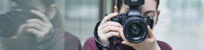 Image of a woman looking into a camera with a flash attached