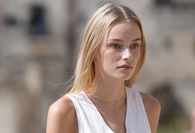 전경에 다른 여성이 지나가고 있는 여성의 인물 사진을 보여주는 예시 이미지