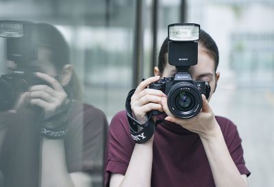 Image of a woman looking into a camera with a flash attached