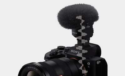 Imagen de la vista frontal superior izquierda de la cámara con el micrófono y el paraviento conectados, y una ilustración de la forma de onda digital del micrófono a la cámara