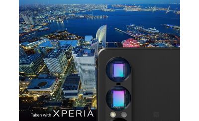 Обратная сторона телефона, на которой крупным планом видны два объектива камеры на фоне ночного городского пейзажа, снятого на Xperia.