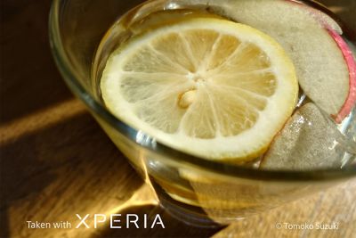 Ломтик лимона, плавающий среди льда в стеклянной чаше на столе. Снято на Xperia.