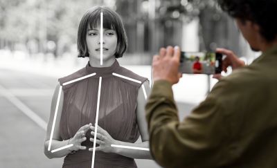 một người chụp ảnh một người khác, nhưng cho thấy cách công nghệ AI tập trung nhận dạng chủ thể bằng các đường kẻ trên cơ thể của người đó