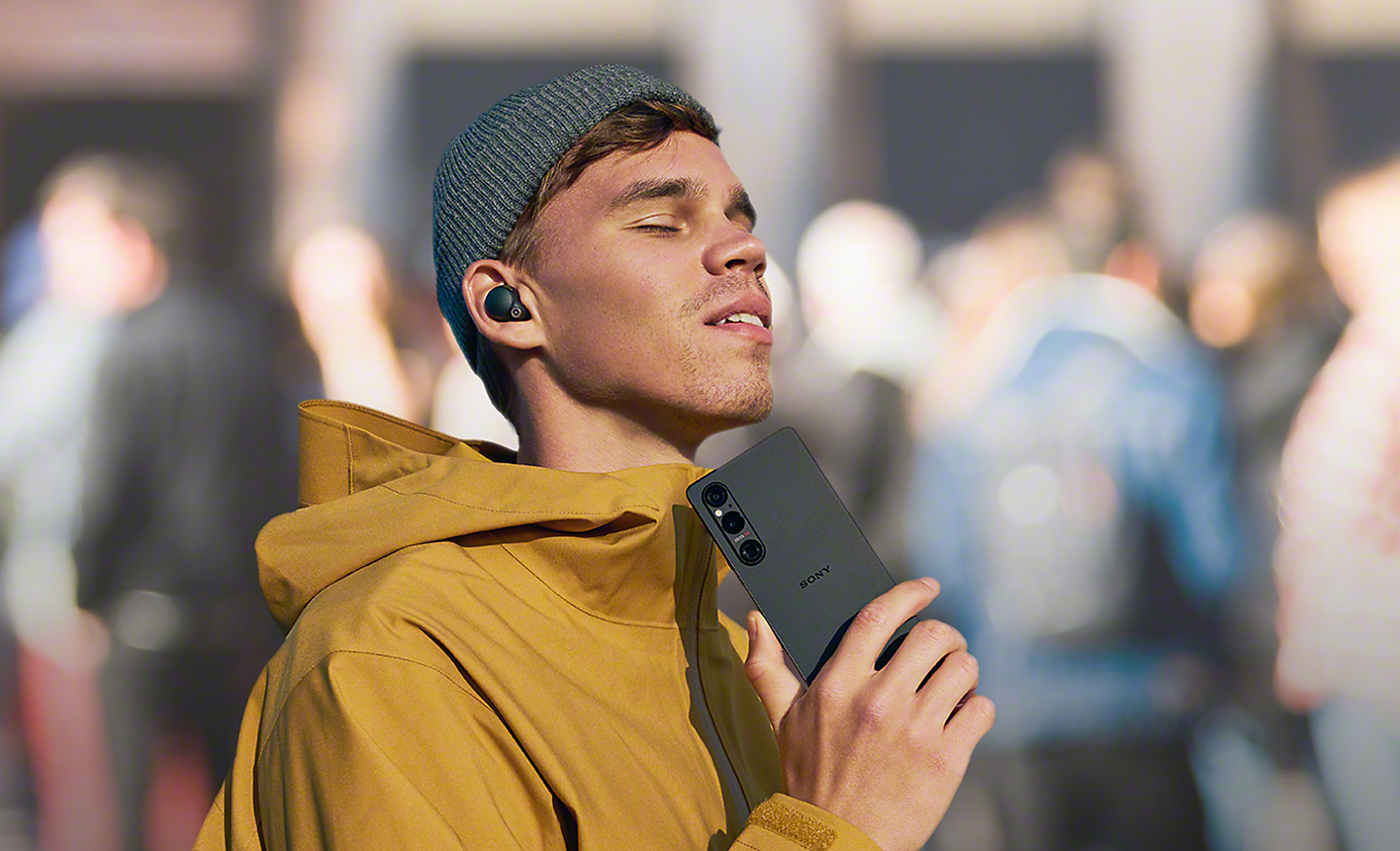 A young person listening to music using the Xperia 1 V and wireless headphones 