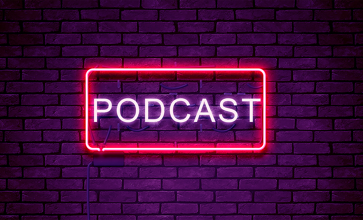 Slovo Podcast obklopené červeným neónovým svetlom, ktoré je namontované na tehlovej stene