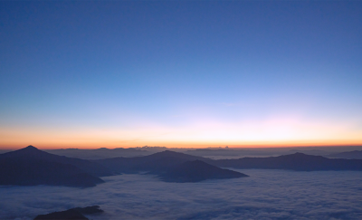 Vista espetacular sobre montanhas distantes envoltas em nuvens baixas ao amanhecer