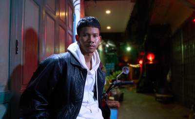 Портрет молодого человека при слабом освещении в городских условиях ночью