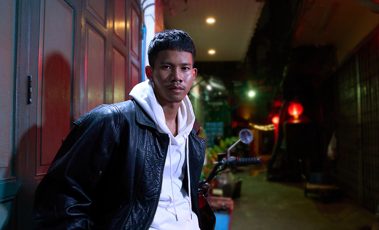 Low-light portrait of a young person in an urban setting at night