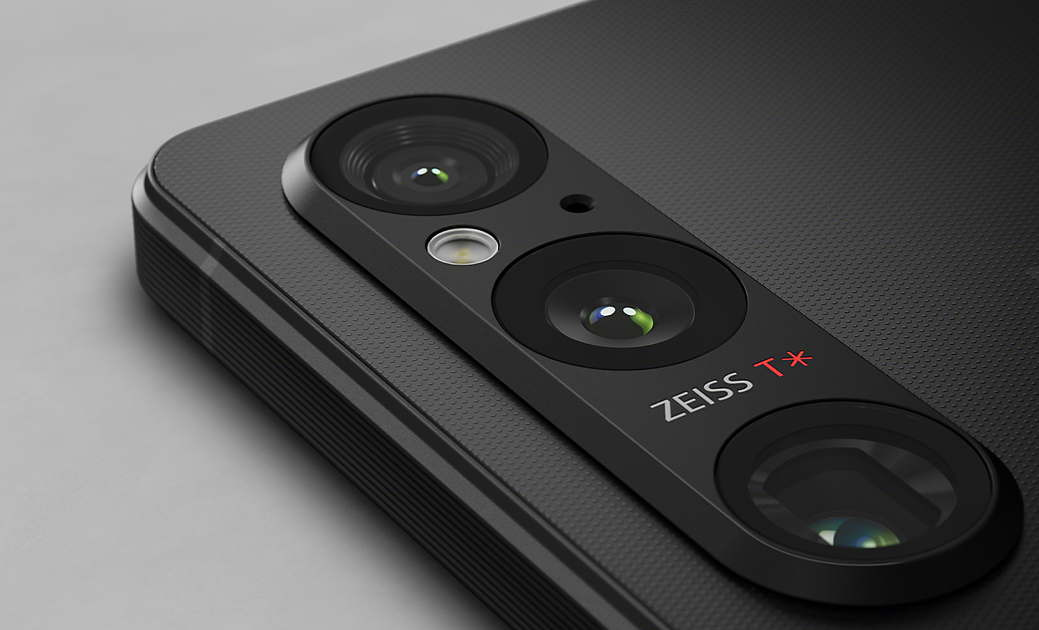 Záber krytu fotoaparátu s tromi objektívmi zblízka na zadnej časti čierneho smartfónu Xperia 1 V