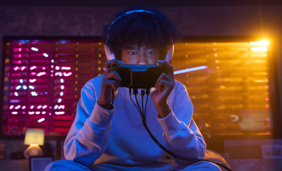 A gamer concentrating hard as he plays on the Xperia 1 V with Xperia Stream gaming gear