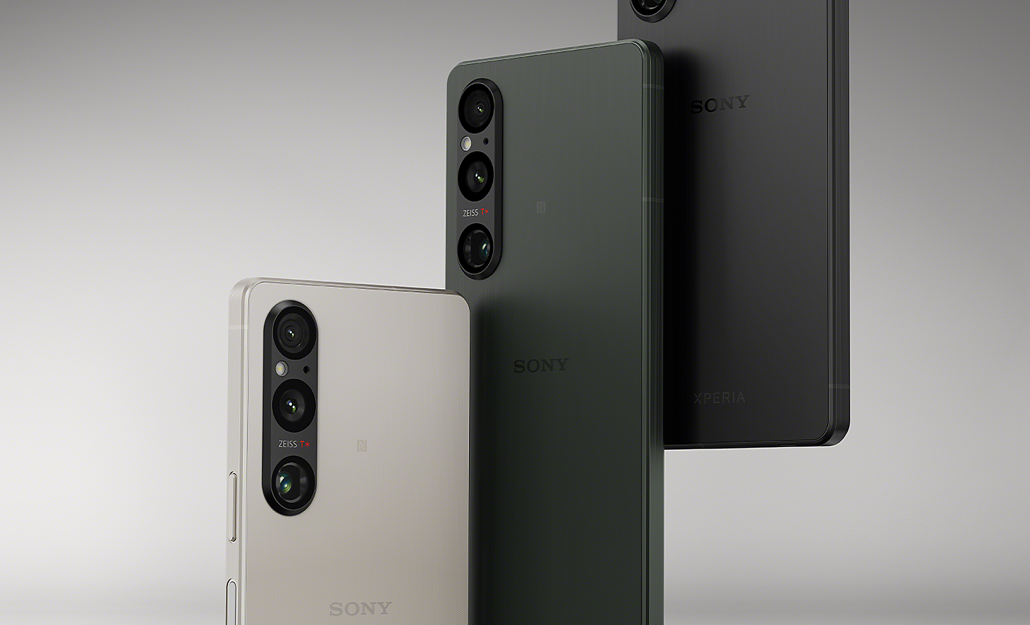 En uppställd rad med tre Xperia V-smartphones i platinasilver, khakigrönt och svart