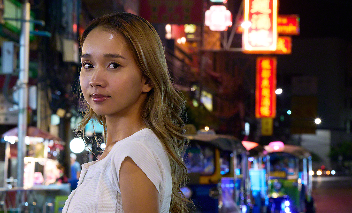 Retrato de uma jovem em uma rua movimentada da cidade à noite