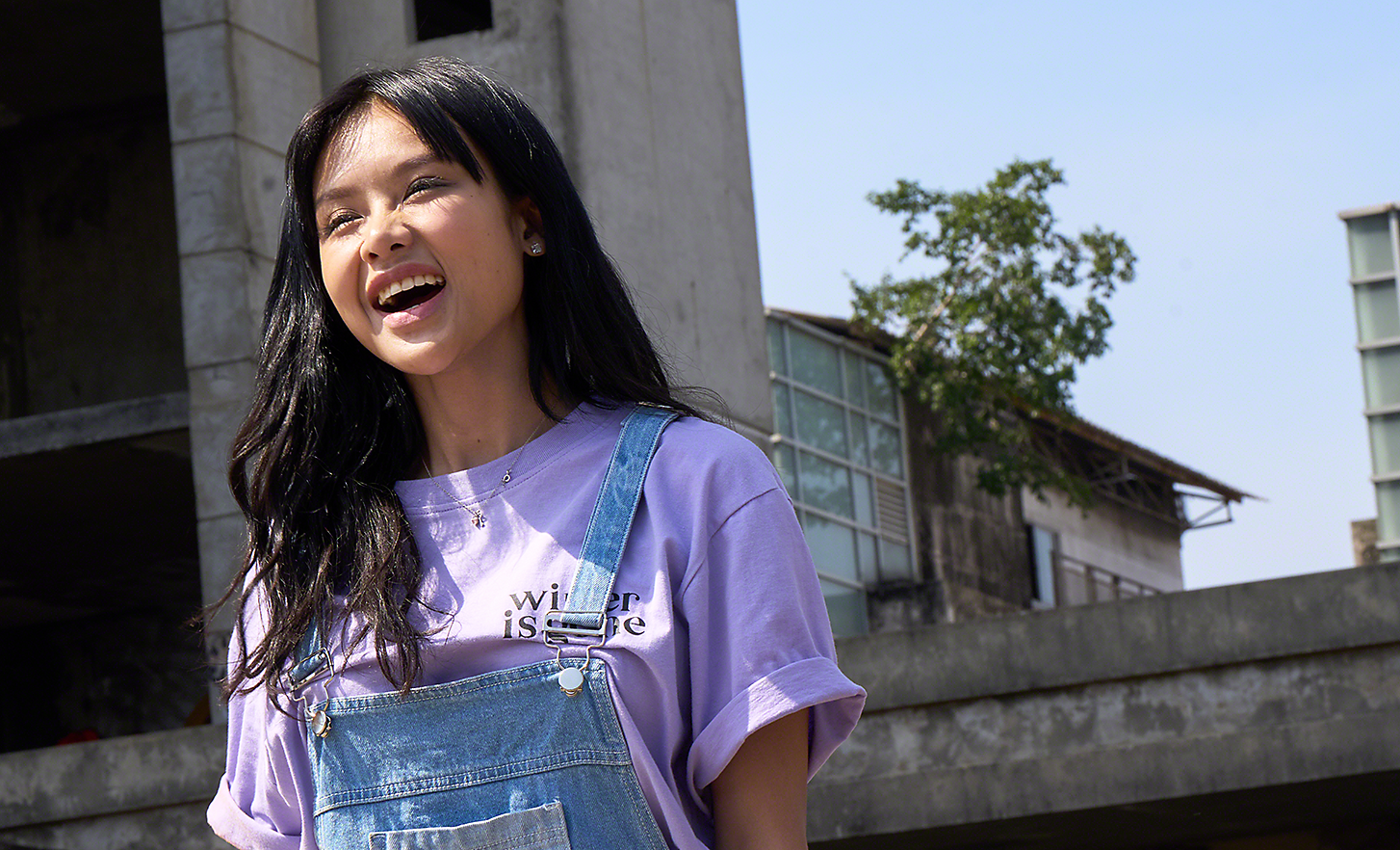 S sončno svetlobo obsijan portret mlade ženske v urbanem okolju