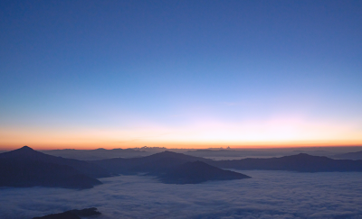 Spectacular view over distant mountains swathed in low cloud at daybreak