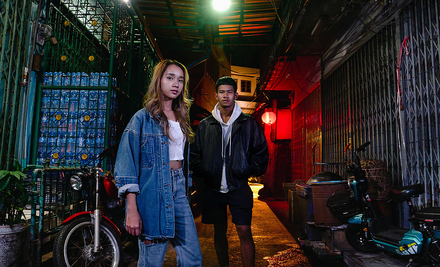 Portret cu două persoane tinere, într-o zonă urbană cu iluminare scăzută