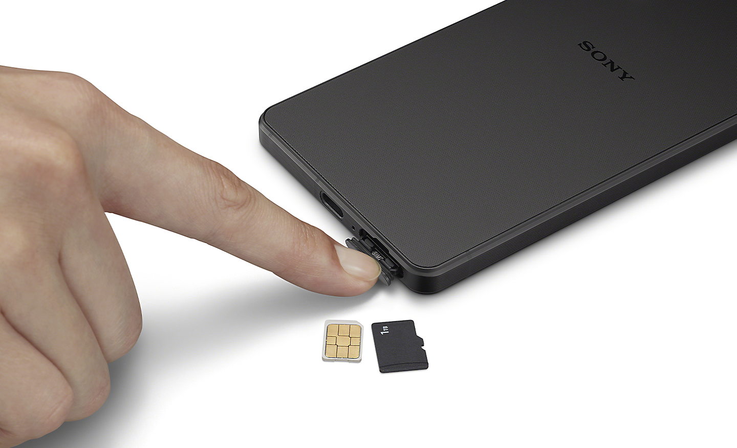 近拍裡某個人利用手指開取 Xperia 1 V 的 SIM 卡托盤