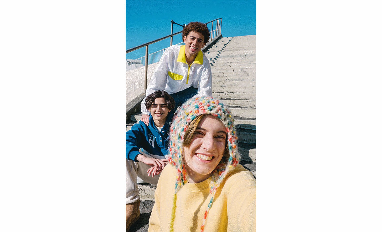 Selfie av tre venner som sitter på noen trapper