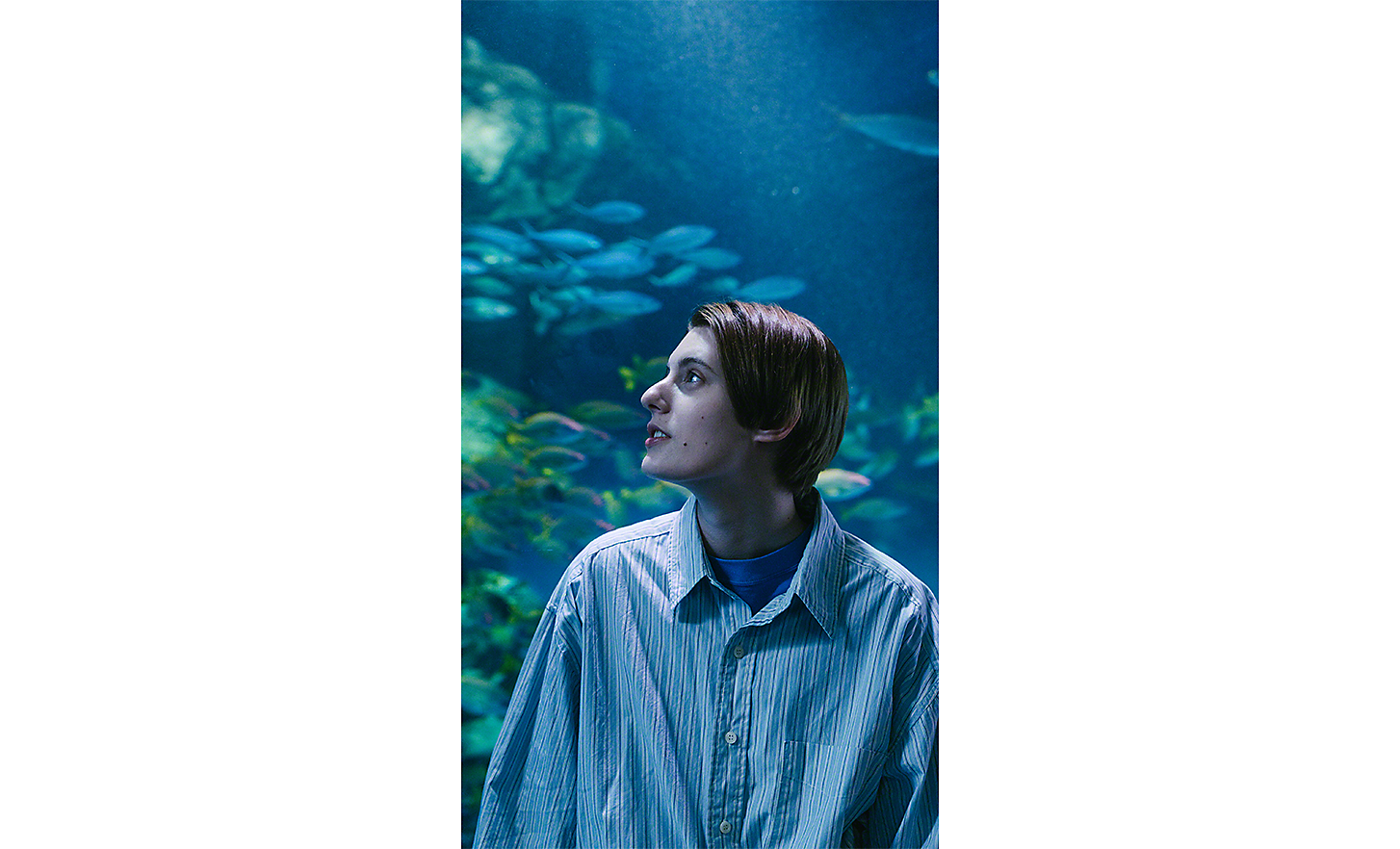 Portrait of a young woman with an aquarium in the background