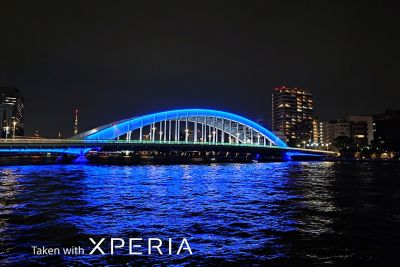 Foto nocturna de un puente con luz azul sobre un río
