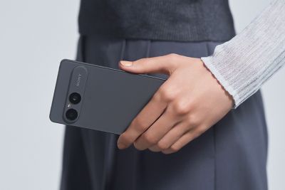 Una persona sostiene un smartphone Xperia 10 VIII en gris esmerilado desde atrás, mostrando su módulo de doble cámara
