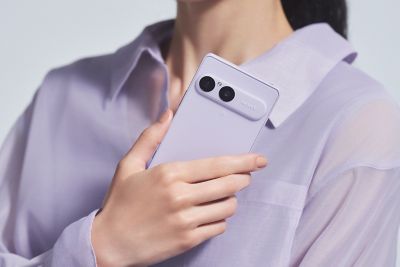 Una persona sostiene un smartphone Xperia 10 VIII en lila suave desde atrás, mostrando su módulo de doble cámara