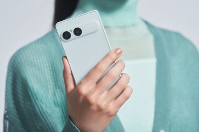 Una persona sostiene un smartphone Xperia 10 VIII en blanco glacial desde atrás, mostrando su módulo de doble cámara