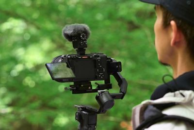 Imagen de uso en la que se ve a un usuario grabando de forma manual con un micrófono y un paravientos acoplados a la cámara