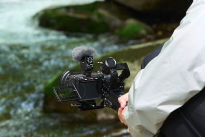 Imagen de uso en la que se muestra la cámara en un estabilizador con un río de fondo