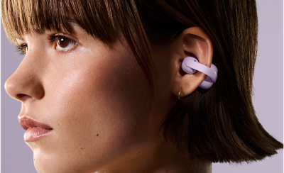 Một người đang đeo tai nghe mở kiểu kẹp tai màu tím.