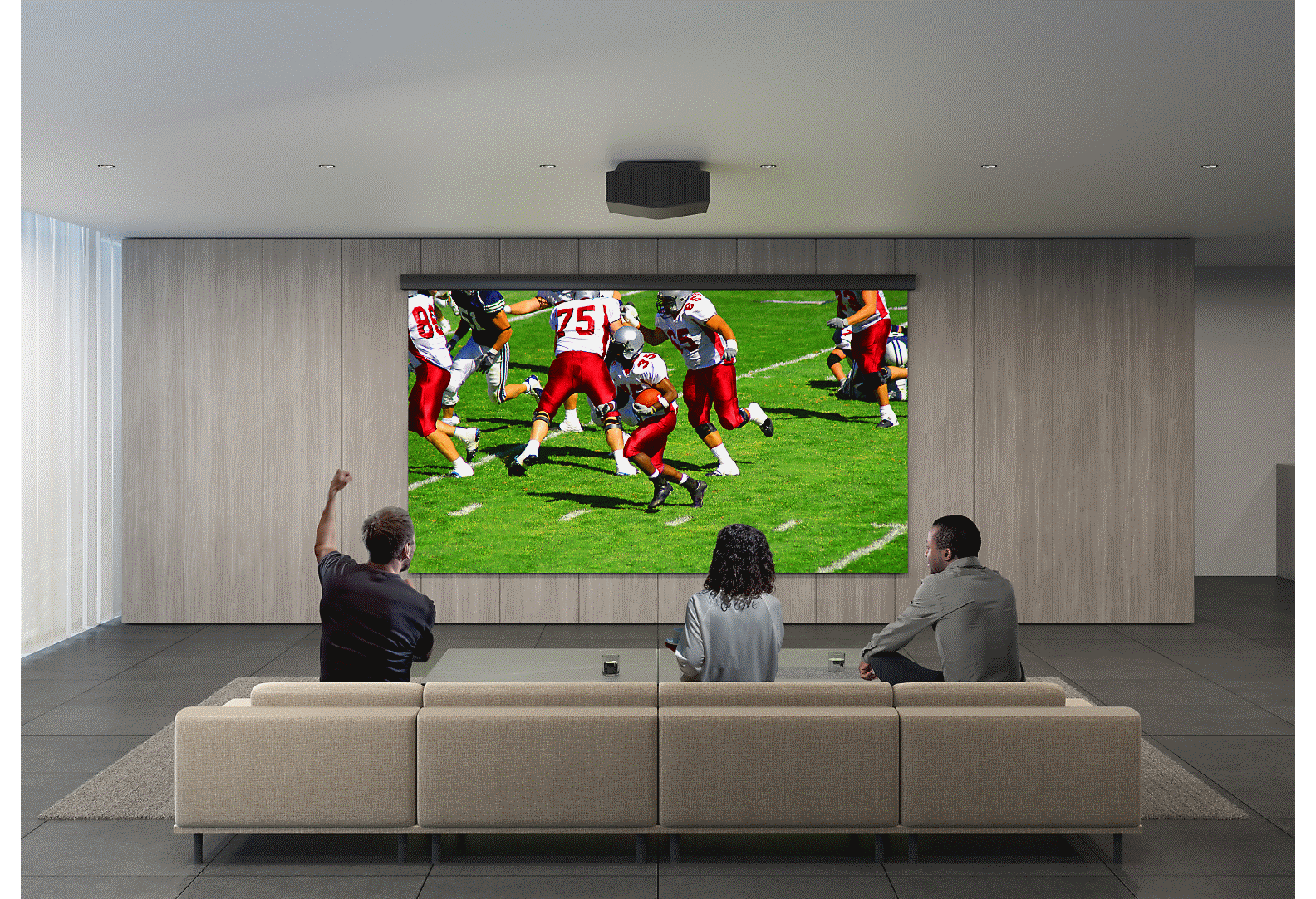 Two men and a woman watching American football game, using a projector and a big screen on the wall.