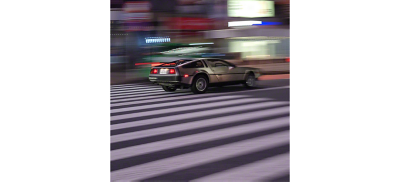 城市中行駛的跑車，背景為模糊的燈光