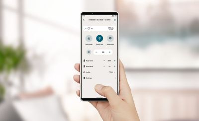 Image of a hand holding a mobile phone displaying a settings menu