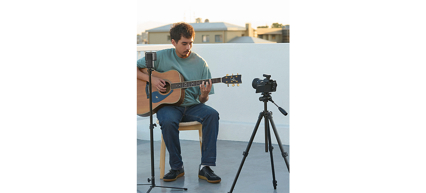 Gambar penggunaan menunjukkan laki-laki bernyanyi melalui mikrofon di atas dudukan sambil bermain gitar di luar ruangan
