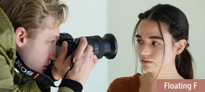 Situational image of a man shooting a close-up of a woman.