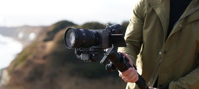 Situational image of a man shooting with the SEL2470GM2 connected to the camera.