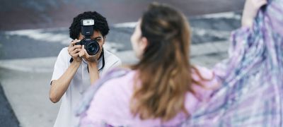 Un hombre captando un retrato al aire libre con el modo de captura continua con flash